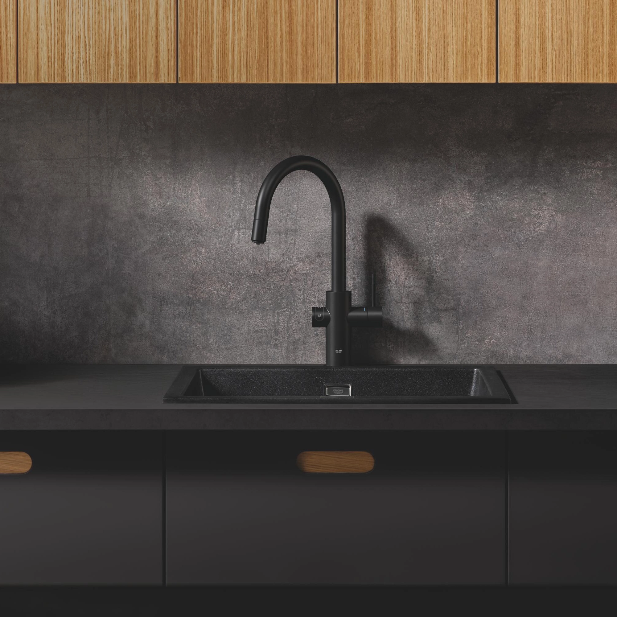 Dark contemporary kitchen with stone worktop and chrome tap filling a tumbler